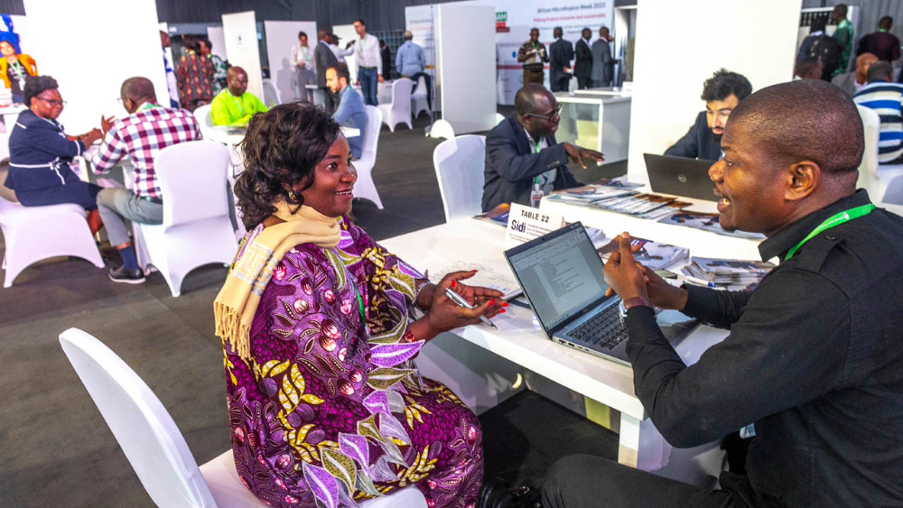 Two people talking around a table with computers