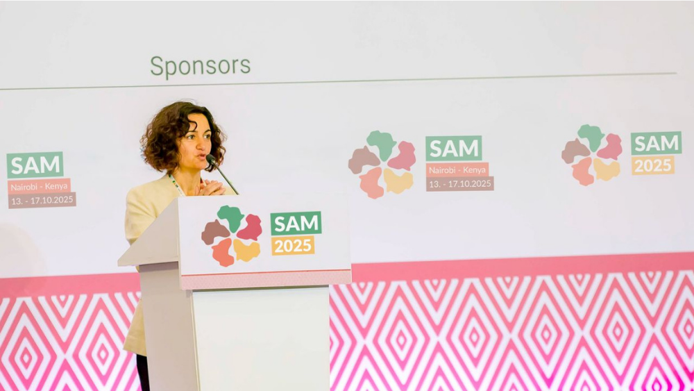 A woman speaking behind a stand