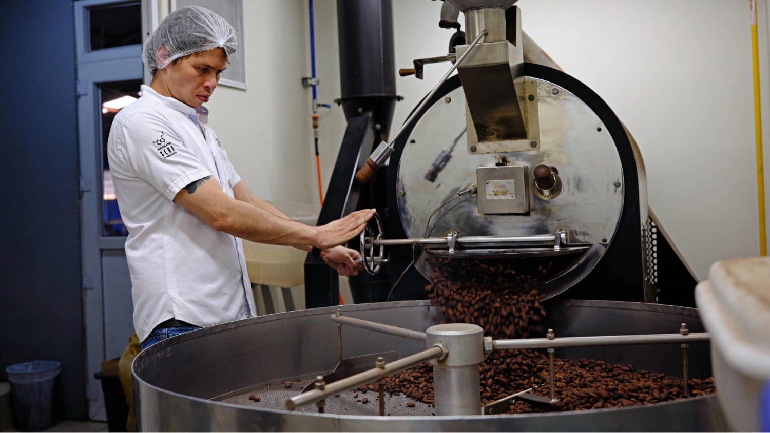 A man presses cocoa beans with a machine
