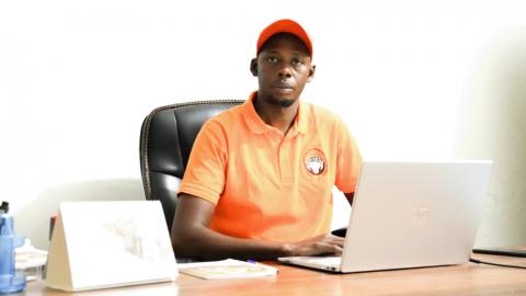 Un homme assis à son bureau devant un PC portable